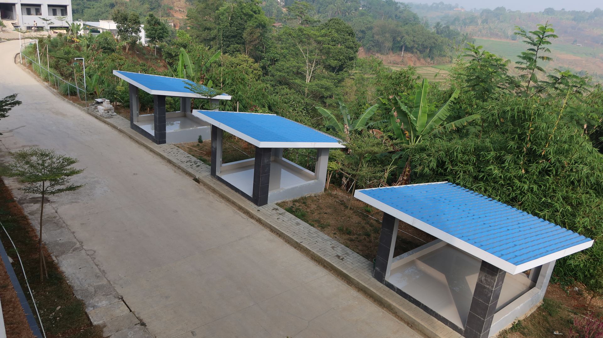 Saung santai di area asri berlatar perbukitan